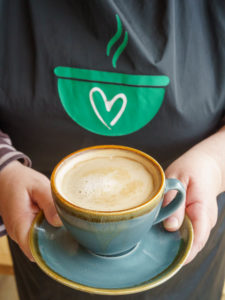 Cafe Staff holding a cup of coffee